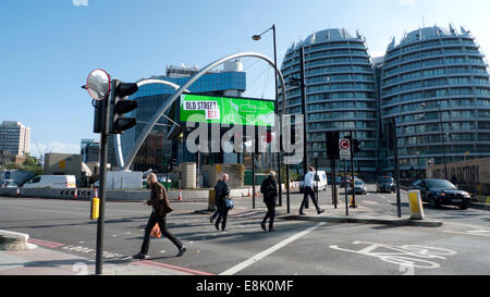 In autunno sole pedoni attraversare Old Street Tech City 'Silicon Roundabout' all'incrocio pedonale con cartello elettronico per affissioni traffico mezzogiorno Shoreditch Londra EC1 Inghilterra Regno Unito KATHY DEWITT Foto Stock