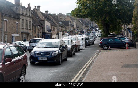 Honeypot Tourist Village street affollata con il traffico a Burford, Oxfordshire, England, Regno Unito Foto Stock
