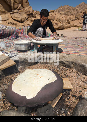 L'Egitto, il Sinai,Beduino Desert Camp, uomo di pasta di laminazione e cottura fatir tradizionale pane piatto Foto Stock