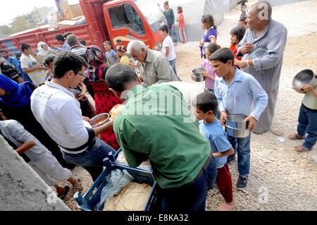 Suruc, Turchia. Il 9 ottobre, 2014. Centinaia e centinaia di rifugiati da Kobane, Siria ricevono cibo in un campo di rifugiati in Suruc, Turchia. Come combattere intenisifies in Kobane vi è un afflusso massiccio di rifugiati in cerca di cibo e riparo. Le stime dell'UNHCR vi sono attualmente oltre 200.000 curdi siriani che sono fuggiti Kobane a causa della minaccia di uno Stato islamico e la intensi combattimenti nella zona. Credito: ZUMA Press, Inc./Alamy Live News Foto Stock