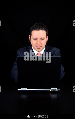 Imprenditore è utilizzando il computer su sfondo nero Foto Stock