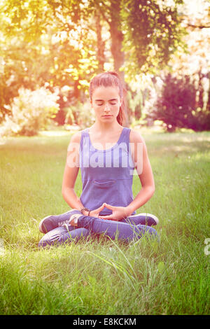 Bella ragazza adolescente medita in natura Foto Stock