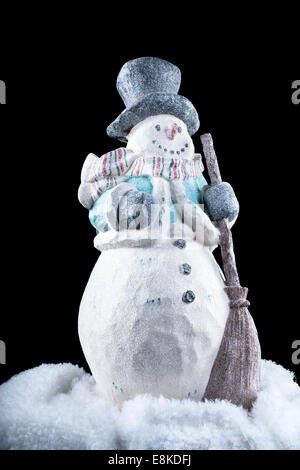 Un pupazzo di neve decorativo al buio, freddo all'aperto durante la stagione delle vacanze. Foto Stock