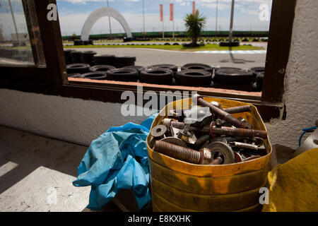 Bullone e dado in una scatola sopra il tavolo. Circuito Karting workshop Foto Stock