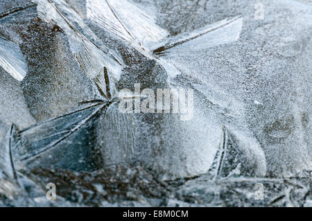 Frost ghiaccio inciso sul veicolo schermo di finestra con un pallido sole imbianchiti dietro. Alimenti biologici e naturali volute e formazioni di cristallinità Foto Stock