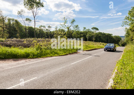 Automobile che viaggia su una salita con una strada di campagna in estate, Nottinghamshire, England, Regno Unito Foto Stock
