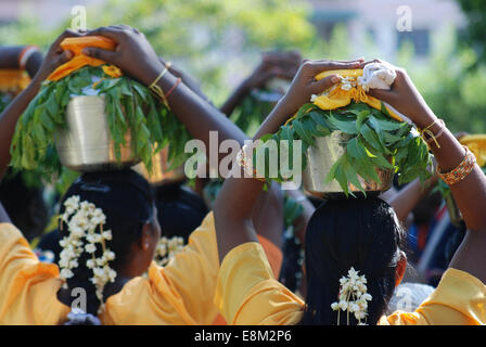 Femmina indù devoti che porta bicchieri di latte sulla testa in festa religiosa, vista posteriore Foto Stock