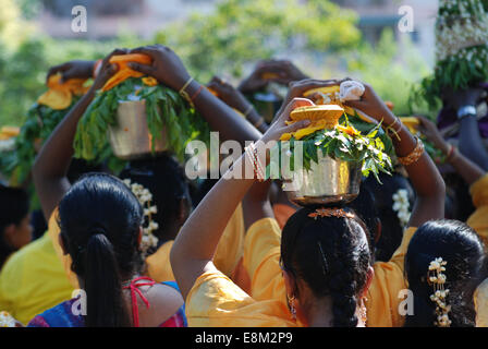 Femmina indù devoti che porta bicchieri di latte sulla testa in festa religiosa, vista posteriore Foto Stock