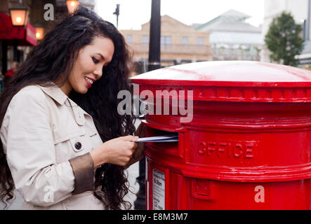 Giovane donna invio di lettere Foto Stock