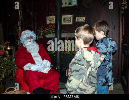 Due bambini piccoli, visita di Babbo Natale nella sua grotta Foto Stock