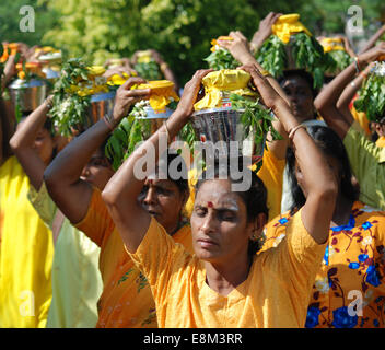 Femmina indù devoti che porta bicchieri di latte sulla testa in festa religiosa Foto Stock