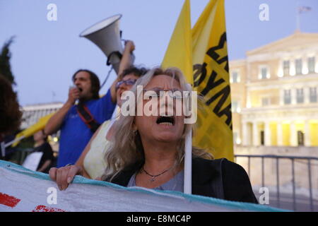 Atene, Grecia. Il 10 ottobre 2014. Un manifestante grida la sua rabbia verso il governo greco. I manifestanti da diversi anti-gruppi di governo hanno protestato fuori del parlamento greco la sera del voto di fiducia al governo greco che si è tenuto all'interno. La protesta è stata prevalentemente diretti contro le misure di austerità introdotte dal governo greco negli ultimi anni. Credito: Michael Debets/Alamy Live News Foto Stock