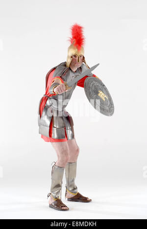 Uomo vestito in costume costume da commedia come un soldato romano, in piena army centurion uniforme in un bianco studio fotografico Foto Stock