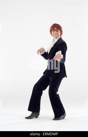 Uomo vestito in costume costume da commedia come Austin Powers, film a carattere in un studio di fotografia contro uno sfondo bianco Foto Stock