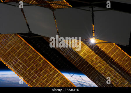 2 gennaio 2014 - Il sole splende attraverso una struttura reticolare a base di pannello del radiatore e di una primaria solar array pannello sulla terra-orbiting Inte Foto Stock