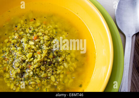 Scotch brodo. Zuppa di orzo in una piastra di colore giallo. Vista superiore Foto Stock