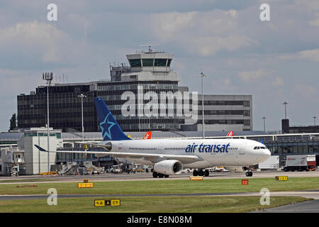 Air Transat Airbus A330-243 rullaggio attraverso la parte anteriore del Manchester Airport edifici Foto Stock