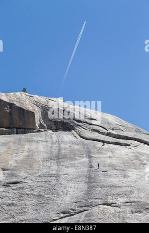 Gli alpinisti nel Parco Nazionale di Yosemite sulla grande roccia di granito con aereo e condensazione trail Foto Stock