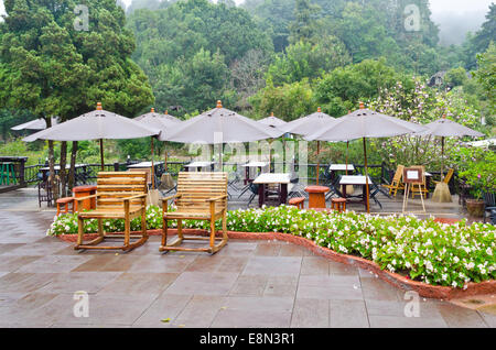 Area con posti a sedere del ristorante circondato da alberi in una foresta sulla montagna, Thailandia Foto Stock