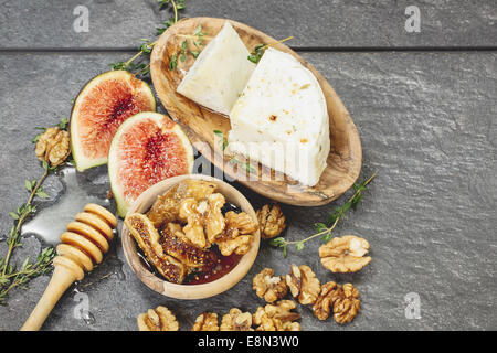 Fichi freschi con miele speziato e formaggio di capra. Fatto con un vintage retrò filtro. Macro, il fuoco selettivo Foto Stock