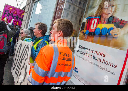 Londra, Regno Unito. Undicesimo oct, 2014. Manifestanti Anti-Fracking HSBC bersaglio nella giornata di azione globale. Simulazione di attrezzatura di trivella, 'fracked acqua', luci di nastro e relatori provenienti da comunità colpite girare due Central London HSBCs si sono trasformate in "live fracking siti' per protestare contro il finanziamento a fracking. 'Global' Frackdown giorno di azione vede 100s di azioni contro fracking in oltre trenta paesi.The Strand, Londra. Credito: Guy Bell/Alamy Live News Foto Stock