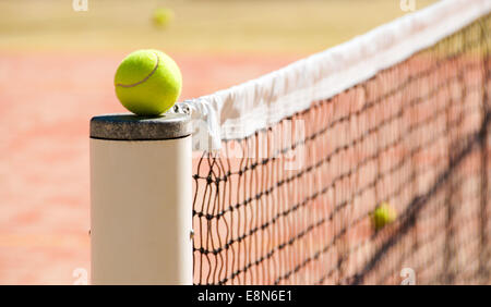 Palle da tennis sulla corte vicino a reti tennis Foto Stock