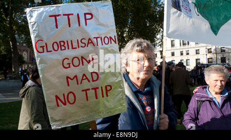 La piazza del Parlamento, Londra UK. 11 ottobre 2014. Manifestazioni hanno luogo con anti TTIP cartelloni in piazza del Parlamento su una comunità ampia giornata di azione di protesta contro il commercio transatlantico & Partnership per gli investimenti che vuole trasferire competenze alle corporazioni distruggendo così i diritti democratici della società specialmente il Servizio Sanitario Nazionale. Kathy deWitt/Alamy Live News Foto Stock