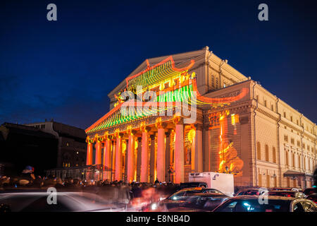 Mosca, Russia. Sabato, Ottobre 11th, 2014. IV cerchio di luce festival internazionale è in corso a Mosca. " La luce del mondo " laser show sul teatro Bolshoi facciata. Il tempio Cinese. La gente paga alcuna attenzione al traffico. Credito: Alex Immagini/Alamy Live News Foto Stock