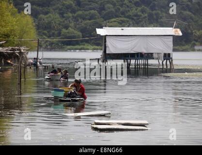 Ilopango, El Salvador. Undicesimo oct, 2014. Le donne lavare i panni nelle acque inquinate del Lago di Ilopango, a 9 km a est di San Salvador, capitale di El Salvador, su 11 ott. 2014. Il lago di Ilopango, di origine vulcanica è inquinato da rifiuti Rifiuti, prodotti agrochimici e arsenico in livelli superiori a quelle evidenziate dalla Organizzazione Mondiale della Sanità (OMS), e nonostante questa situazione, residenti utilizzare l'acqua per fare fatica quotidiana, quali la cottura, il lavaggio e la balneazione, secondo la stampa locale. © Oscar Rivera/Xinhua/Alamy Live News Foto Stock