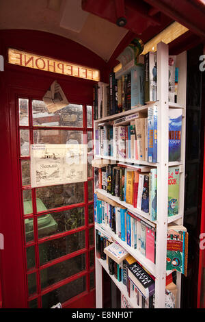 Regno Unito, Inghilterra, Devon, Sheepwash, ridondante vecchio rosso K6 casella telefono utilizzato come villaggio prenota exchange Foto Stock