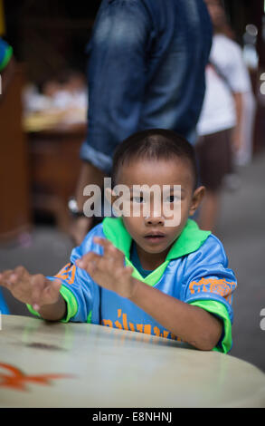 Ragazzo giovane svolge un tamburo cinese durante l'annuale festival vegetariano, Saan Jao Joe Sue Gong, Talad Noi, Bangkok, Thailandia. Foto Stock