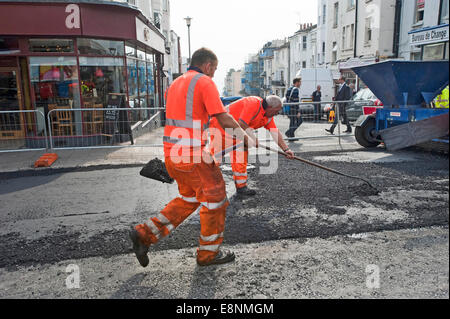 Foto di Roger Bamber : 23 Settembre 2014 : Autostrada operai stradali diffondere i trucioli dal Chipper su una spianata la strada principale Foto Stock