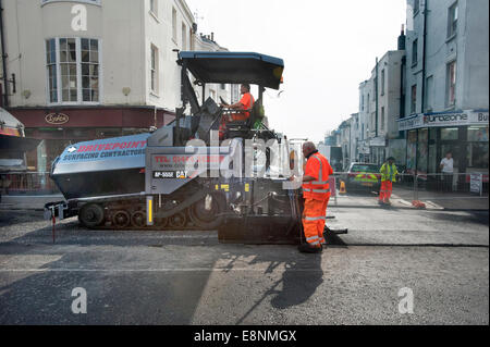 Foto di Roger Bamber : 23 Settembre 2014 : un Caterpillar manto stradale lastricatore riemerge una strada principale in Brighton East Sussex Foto Stock