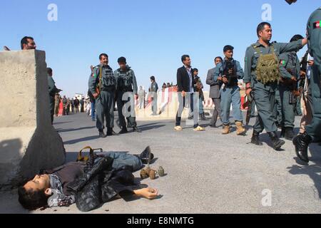 (141012) -- Mazar-I-Sharif, Ottobre 12, 2014 (Xinhua) -- Le persone si radunano attorno al corpo di un terrorista dopo un attacco a Mazar-i-Sharif città, provincia Balkh, Afghanistan settentrionale, il 12 ottobre 2014. Circa 18 poliziotti sono stati feriti dopo due militanti che indossano uniformi della polizia ha aperto il fuoco all'interno della polizia provinciale sede a Mazar-i-Sharif, città capoluogo di provincia del nord Balkh afgano provincia domenica, fonti. (Xinhua/Azorda)(zhf) Foto Stock