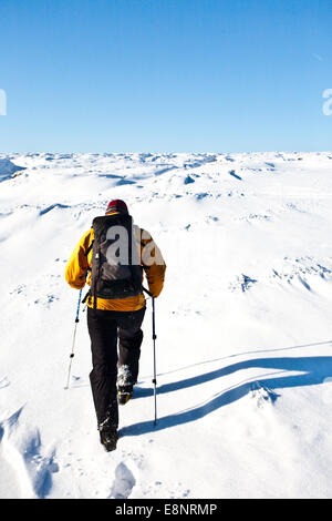 Un alpinista snow shoeing sulla Kinder Altopiano del Peal District National Park, Derbyshire, in Inghilterra, Regno Unito Foto Stock