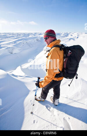 Un alpinista snow shoeing sulla Kinder Altopiano del Peal District National Park, Derbyshire, in Inghilterra, Regno Unito Foto Stock