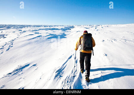 Un alpinista snow shoeing sulla Kinder Altopiano del Peal District National Park, Derbyshire, in Inghilterra, Regno Unito Foto Stock