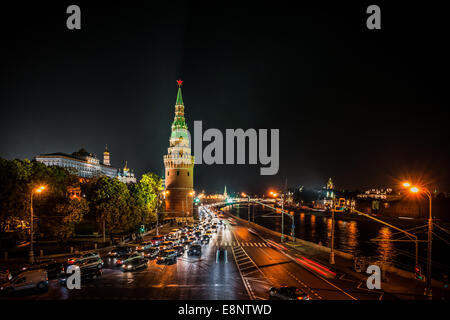 Mosca, Russia. Sabato, Ottobre 11th, 2014. Meteo: Inaspettatamente caldo giorno era qui a Mosca il sabato. Di giorno la temperatura è salito a +17 gradi centigradi (63F). La serata è stata anche tranquilla, confortevole e caldo. La gente ha scelto di essere fuori per godere degli ultimi il calore della stagione. Il traffico pesante verso il basso il terrapieno Kremlevskaya. Gran Palazzo del Cremlino (sinistra), torre Vodovzvodnaya del Cremlino (al centro), il fiume di Mosca (a destra). Credito: Alex Immagini/Alamy Live News Foto Stock