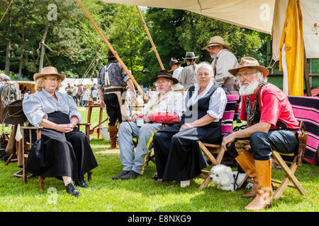 Il Porro England Regno Unito 21 Giugno 2014. Un gruppo di uomini e donne seduti intorno in un campo aperto campeggio vestito in USA abiti da cowboy. Foto Stock