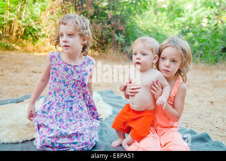 Tre piccoli bambini guardano con espressioni di soprassalto Foto Stock