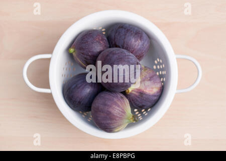 Ficus carica. Le figure in un colapasta di smalto su una tavola di legno. Foto Stock