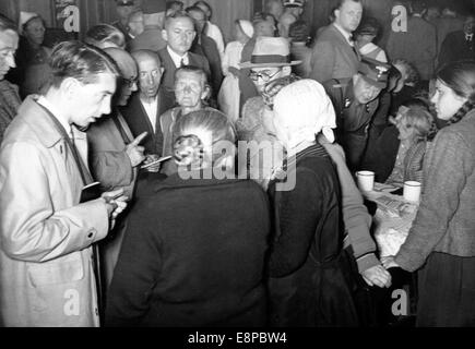 L'immagine da un nazista news report mostra Sudeti tedesco rifugiati fuggiti dalla Cecoslovacchia essendo poste domande dei giornalisti stranieri in un campo di rifugiati in Reichenbach, Germania, settembre 1938. La propaganda originale testo sul retro della foto si legge: "i giornalisti stranieri visita con tedeschi dei Sudeti. Un gruppo di giornalisti stranieri ha visitato alcuni campi profughi al confine ceco di ieri. Le esperienze dei rifugiati sono straziante, la loro sofferenza che è stata inflitta su di essi è disumana. I giornalisti stranieri sono date una foto delle loro esperienze di Reichenbach Refugee Camp". Foto Stock