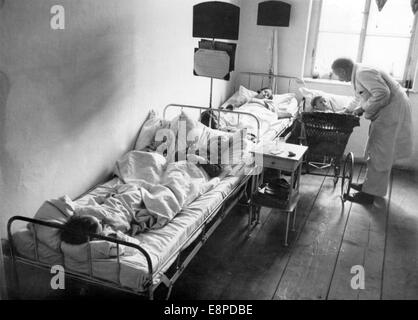 Una vista in un Sudeti ospedale tedesco in ceco Elbogen (Looket) nel maggio 1938. La foto è stata utilizzata dai nazisti a mostra le cattive condizioni di vita dei tedeschi dei Sudeti in Cecoslovacchia. Il nazista news service scrive sul retro dell'immagine: "Ci accusano! (Visita con tedeschi dei Sudeti.) l'ospedale in Elbogen. Il "isolamento caserma" dall'interno! La foto è stata scattata in un momento in cui l'ospedale fu sparsamente occupato. In caso contrario, 4 bambini si trovano in ogni letto, mescolati insieme da varie famiglie con varie malattie infettive. Scarlattina, il morbillo, la difterite. Il tutto sotto una coperta. N. Foto Stock