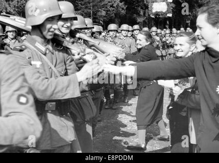 La foto della propaganda nazista mostra che le donne accolgono le truppe tedesche a Braunau, Sudetenland (oggi Broumov, Repubblica Ceca) nell'ottobre 1938. Il testo originale del servizio di notizie nazista sul retro della foto recita: "L'arrivo delle truppe tedesche nella divisione V. Nessun soldato tedesco marcia senza fiori nel Sudetenland liberato: Le donne tedesche Sudeten decorano i soldati che marciano attraverso Braunau con fiori”. Fotoarchiv für Zeitgeschichtee - NESSUN SERVIZIO DI CABLAGGIO Foto Stock