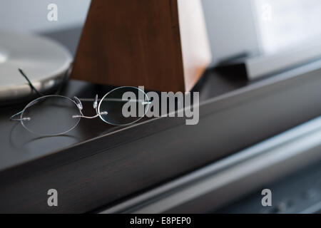 Occhiali poggiano su un piano in un pozzo sala it Foto Stock