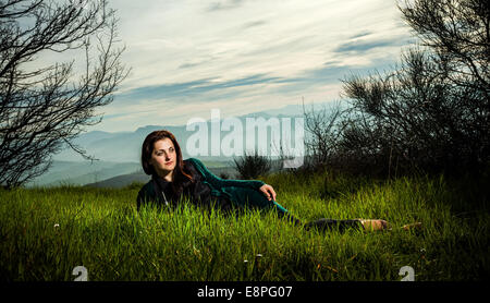 La donna posa sull'erba verde Foto Stock