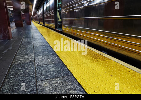 Pendolari attendere che si avvicina il treno della metropolitana di New York City 34 Street Foto Stock