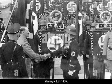 Rally di Norimberga 1937 a Norimberga, Germania - Adolf Hitler consacra nuovi standard con la "Blood Flag" durante la chiamata di Sturmabteilung (SA), Schutzstaffel (SS) e National Socialist Motor Corps (NSKK), qui stretta di mano dopo la consacrazione. Nuovi standard sono stati consacrati toccandoli con la "Blood Flag" che presumibilmente è stata portata nel fallito Beer Hall Putsch di Monaco. (Difetti di qualità dovuti alla copia storica dell'immagine) Fotoarchiv für Zeitgeschichtee - NESSUN SERVIZIO DI CABLAGGIO - Foto Stock