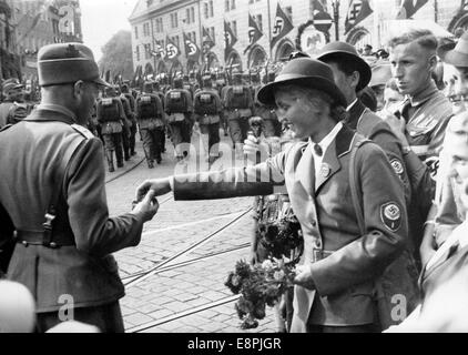 Norimberga Rally 1937 a Norimberga, Germania - Un membro femminile del Reich Labour Service (RAD) offre rinfreschi ai membri maschi del RAD mentre si marciano per le strade della città con le spade e le zaini. (Difetti di qualità dovuti alla copia storica dell'immagine) Fotoarchiv für Zeitgeschichtee - NESSUN SERVIZIO DI CABLAGGIO - Foto Stock