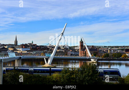 Derry, Londonderry, Irlanda del Nord. Xiii Octc, 2014. Regno Unito: meteo sole autunnale. La metà giornata Londonderry a Belfast treno passa Derry iconici ponte di pace nel luminoso sole autunnale. Il secco clima autunnale è di continuare in Irlanda del Nord. Credito: George Sweeney/Alamy Live News. Foto Stock